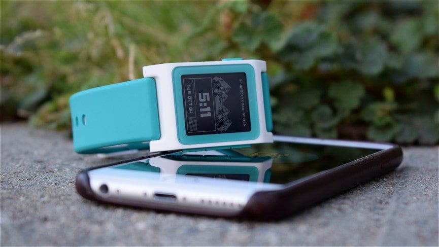 smartwatch lying on top of iPhone