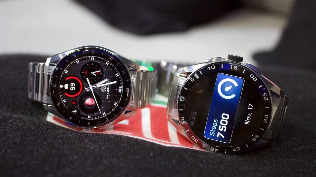 two tag heuer smartwatches sitting next to each other