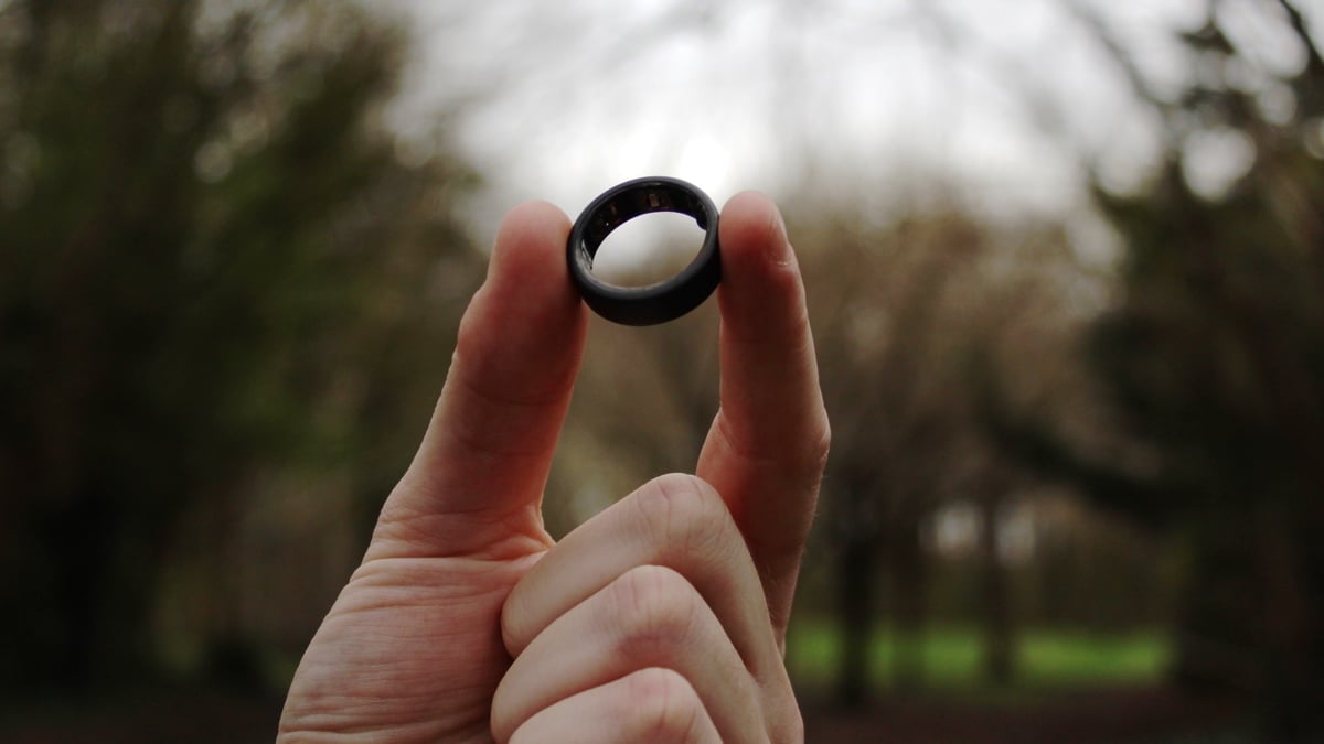 smart ring held up forest background