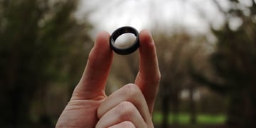 smart ring held up forest background